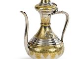 an antique silver and gold tea pot with a lid