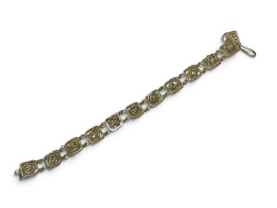 un gros plan d'un bracelet en métal sur fond blanc