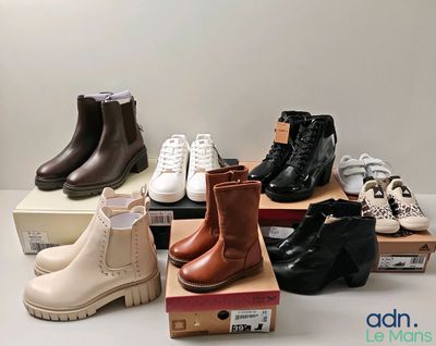 plusieurs paires de chaussures d'enfants posées sur des cartons, sur une table