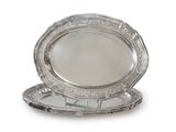 two silver plate with a mirror on top of it on a white surface
