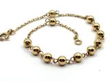 gros plan d'un bracelet en or sur fond blanc