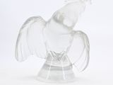 translucent glass figurine of a bird with a crown on it ' s head