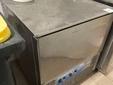 a small stainless steel refrigerator in the corner of a kitchen