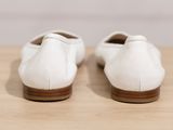 pair of white shoes sitting on top of a wooden table