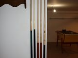 a picture of a room with a pool table and a rack of cues