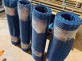 four blue plastic pipes are lined up on the floor in front of a cage
