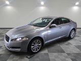 La Jaguar argentée est garée dans une grande pièce.