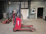 a red fork lift truck in a garage with other equipment