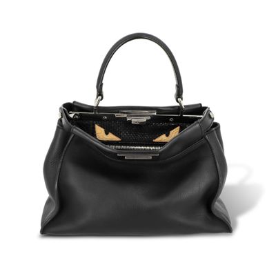 un sac à main en cuir noir avec des détails dorés sur la poignée