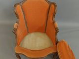 an orange chair with a cushion on top of it on a gray surface