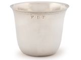 an antique silver cup with a handle on a white background