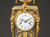 une horloge dorée et blanche posée sur une table en marbre