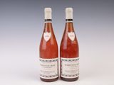 two bottles of wine sitting next to each other on a white surface