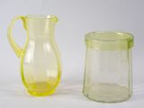 des pichets en verre jaunes et verts posés côte à côte sur une surface blanche