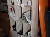 une planche de surf orange appuyée contre une bibliothèque