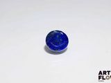 a blue stone sitting on top of a white surface