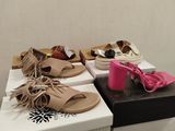 several pairs of shoes are stacked on top of boxes in a room