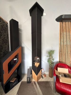 a living room with a red chair and a black fireplace