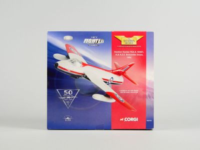une boîte contenant un petit avion-jouet, posée sur une surface blanche