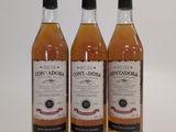 trois bouteilles de whisky posées sur une surface blanche