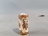 a small vase sitting on a table with a pencil in the background
