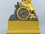 une horloge en or avec une femme assise dessus