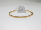 a close up of a gold bracelet with a price tag on it