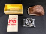 a small box with a camera and some other items on a table