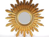 un miroir en forme d'étoile dorée accroché à un mur blanc