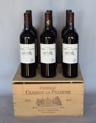 trois bouteilles de vin rouge dans un coffret en bois sur une table