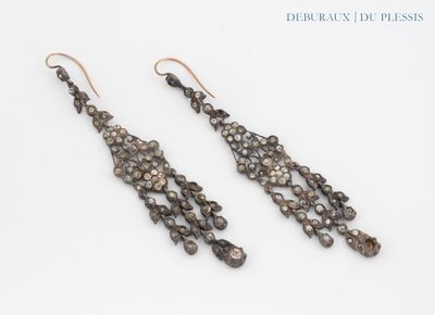 a pair of earrings made of silver and brown glass beads