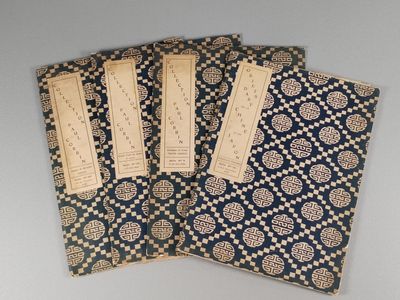 quatre couvertures de livres bleues et dorées ornées d'un motif