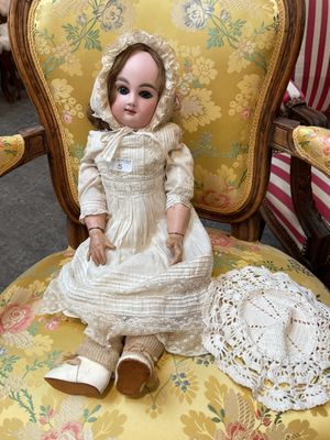une poupée assise sur une chaise dans une pièce