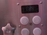 a close up of a clock on the side of a refrigerator