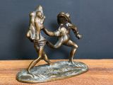 statue of a man and a woman holding hands on a wooden table