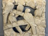 sculptures représentant deux perroquets sur une branche d'arbre, dans un cadre sculpté