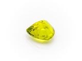 a close up of a yellow diamond on a white surface