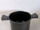 a black pot with a handle on a white table