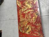 a red book with gold designs on it sitting on the floor