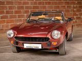 an image of a red sports car parked in front of a brick wall