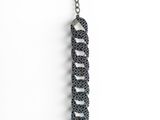 a close up of a metal chain with a black bead on it