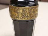 a black and gold vase sitting on a white table