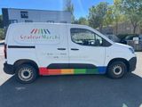 a white van parked in front of a building with a colorful sticker on the side