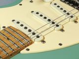 an electric guitar with a green body and a white fret