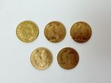 quatre pièces d'or posées sur une surface blanche