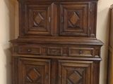 a wooden cabinet in a room with a white tile floor