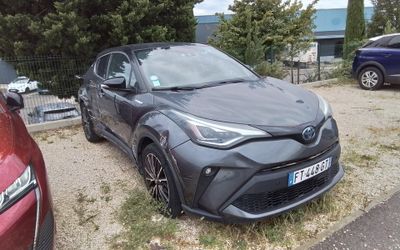a toyota c - hr parked in a parking lot next to other cars