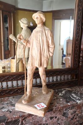 une statue représentant un homme muni d'une canne, posée sur un plan de travail en marbre