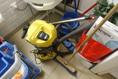 un aspirateur jaune et un seau bleu posés par terre