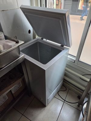 un grand congélateur posé dans un coin de la cuisine